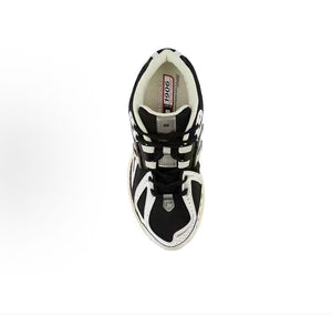 New Balance shoes 1906R running sneaker in black and white, top-down perspective showing black mesh uppers, white leather structural toe overlays, tongue lace-loop branding, and Ortholite inner soles.