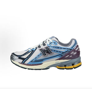 Lateral side profile view of white, blue, and purple New Balance shoes 1906R.