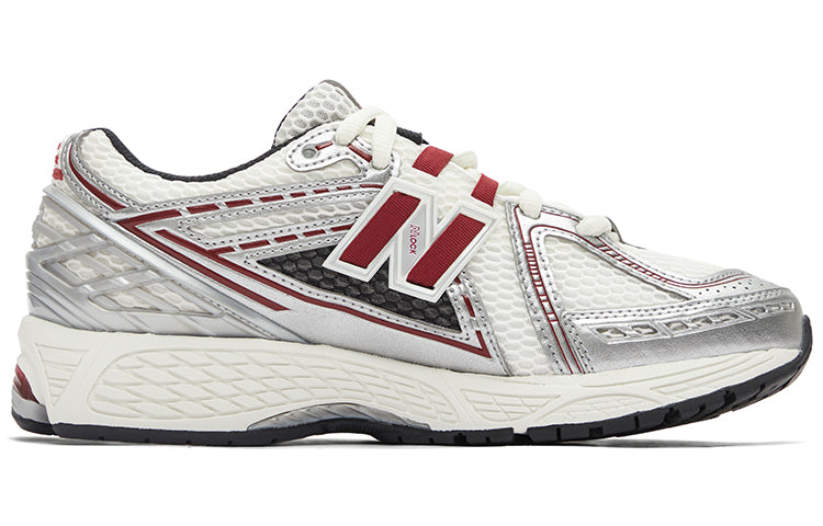 Medial side profile of white, silver, and red New Balance shoes 1906R model, featuring a breathable white mesh base with metallic silver overlays, burgundy-red N-lock lace webbing, a silver molded TPU heel counter, and an off-white N-ergy cushioned midsole.