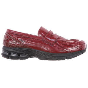 Detailed side perspective highlighting حذاء نيو بالانس featuring the distinctive glossy patent leather finish.