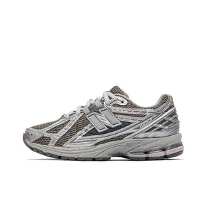New Balance shoes 1906R in metallic silver and dark grey colorway, lateral profile showing breathable mesh, intricate tech overlays, and N-ergy midsole cushioning