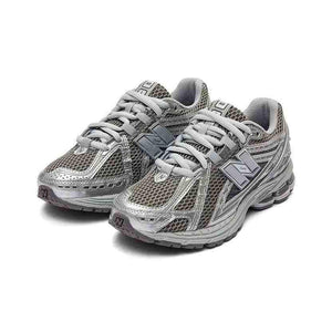 Pair of dark grey and metallic silver New Balance shoes shown at a three-quarter angle, featuring breathable wide-mesh uppers, silver metallic cage overlays, grey laces, and cushioned soles
