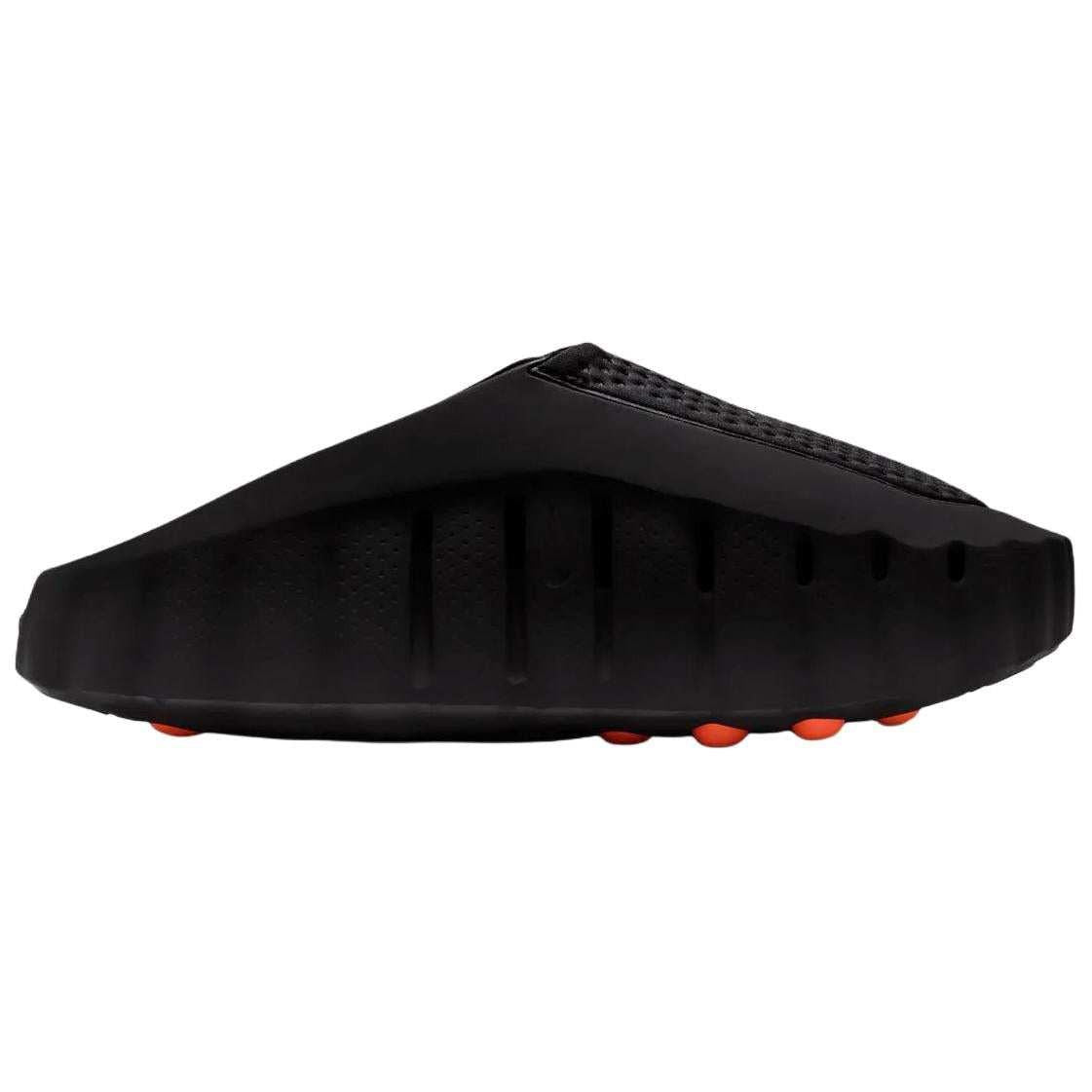 Studio profile shot of the Nike Mind 001 black slide, highlighting the clean architectural silhouette and distinctive lower ventilation grooves.
