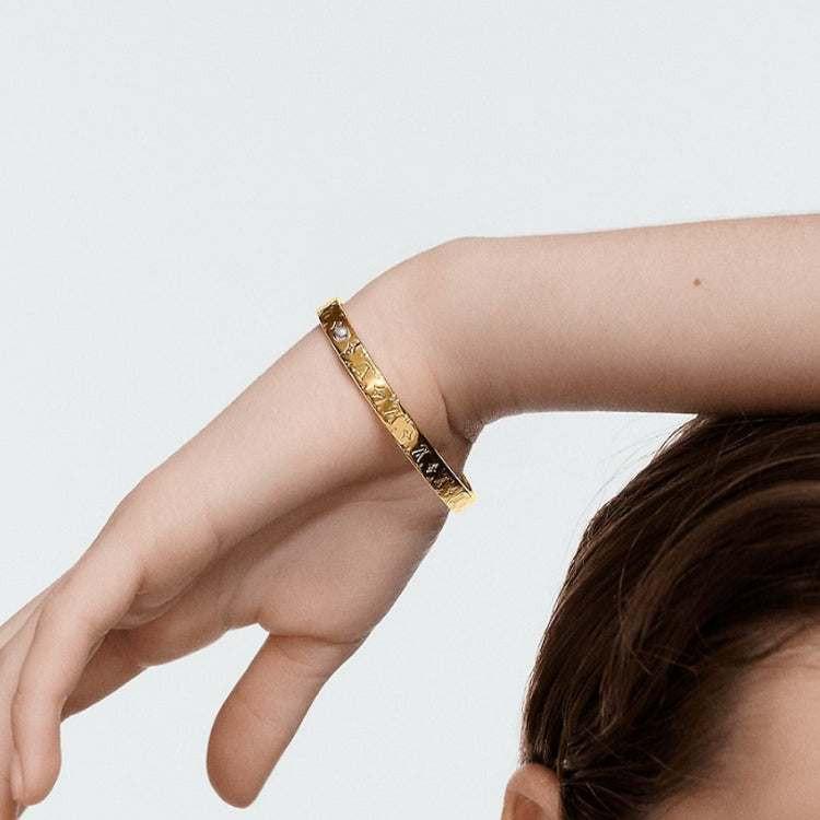 LOUIS VUITTON Logo engraved metal bracelet women's gold.