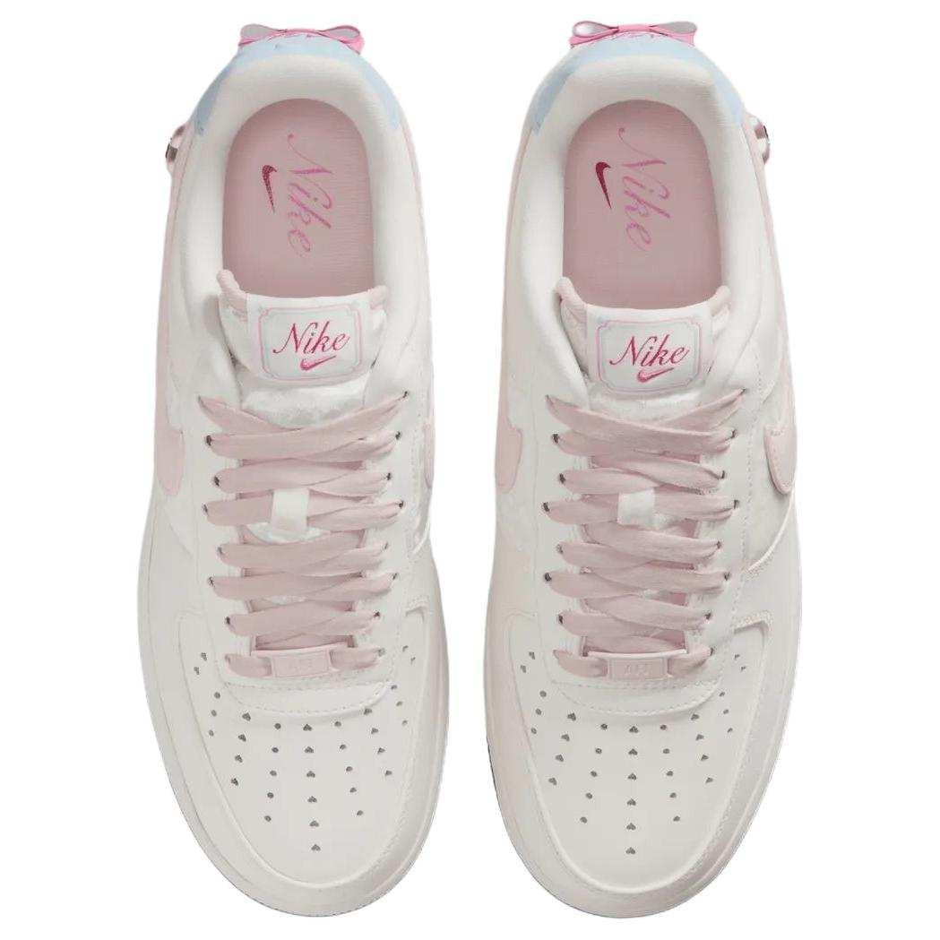 حذاء Nike Air Force 1 أبيض مزين بفيونكة وقلب وردي.