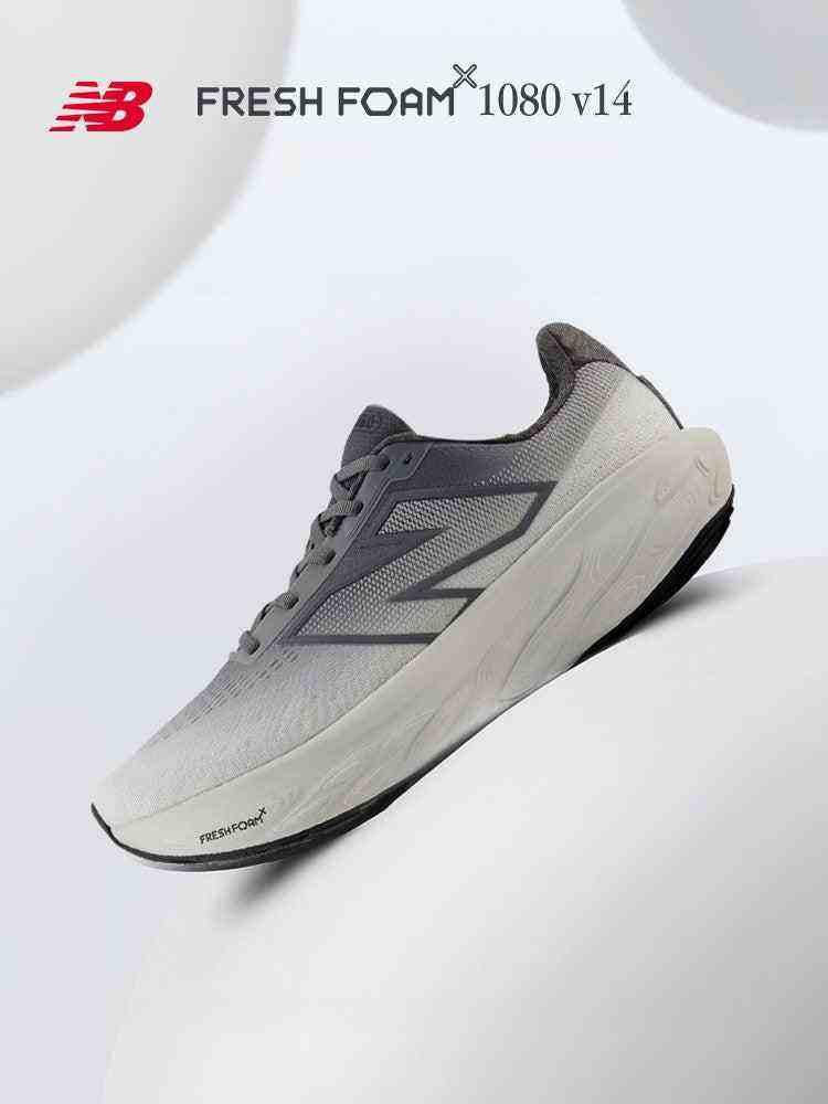 Angled front-side view of a grey New Balance Fresh Foam X 1080 v14 running shoe resting on a smooth surface, featuring "FRESH FOAM X 1080 v14" text across the top.