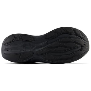Bottom view of an all-black New Balance running shoe, displaying the full rubber outsole with textured, wave-like traction patterns and flex grooves