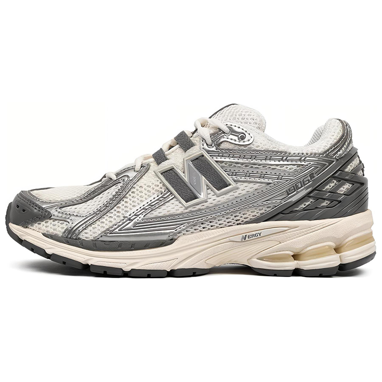 Lateral side profile of metallic silver and cream New Balance shoes 1906R model, featuring breathable open-cell mesh uppers, metallic silver synthetic overlays, dark grey N-Lock lacing webbing, charcoal heel TPU support cage, and an aged cream N-ergy cushioned midsole.