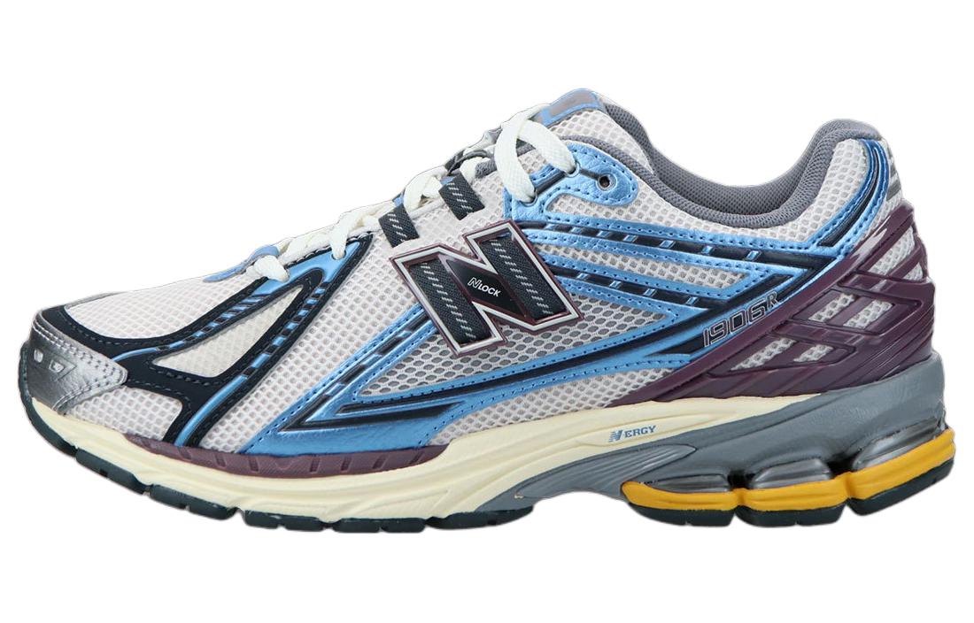 Lateral side profile of white, blue, and purple New Balance shoes 1906R model, featuring a white mesh base, metallic light blue and navy overlays, deep purple heel TPU cage, N-lock side branding, and a cream-and-grey N-ergy cushioned sole with yellow heel pods.