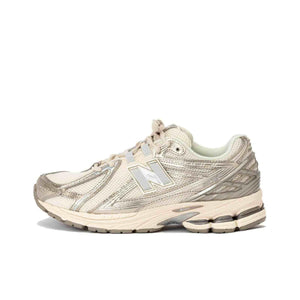 Lateral side view profile of cream and metallic silver New Balance running shoes.
