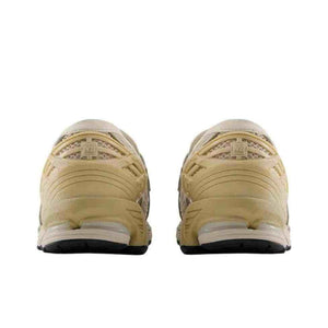 Rear angle view of the New Balance 1906L Beige and Yellow showing the supportive heel cushioning and midsole details.