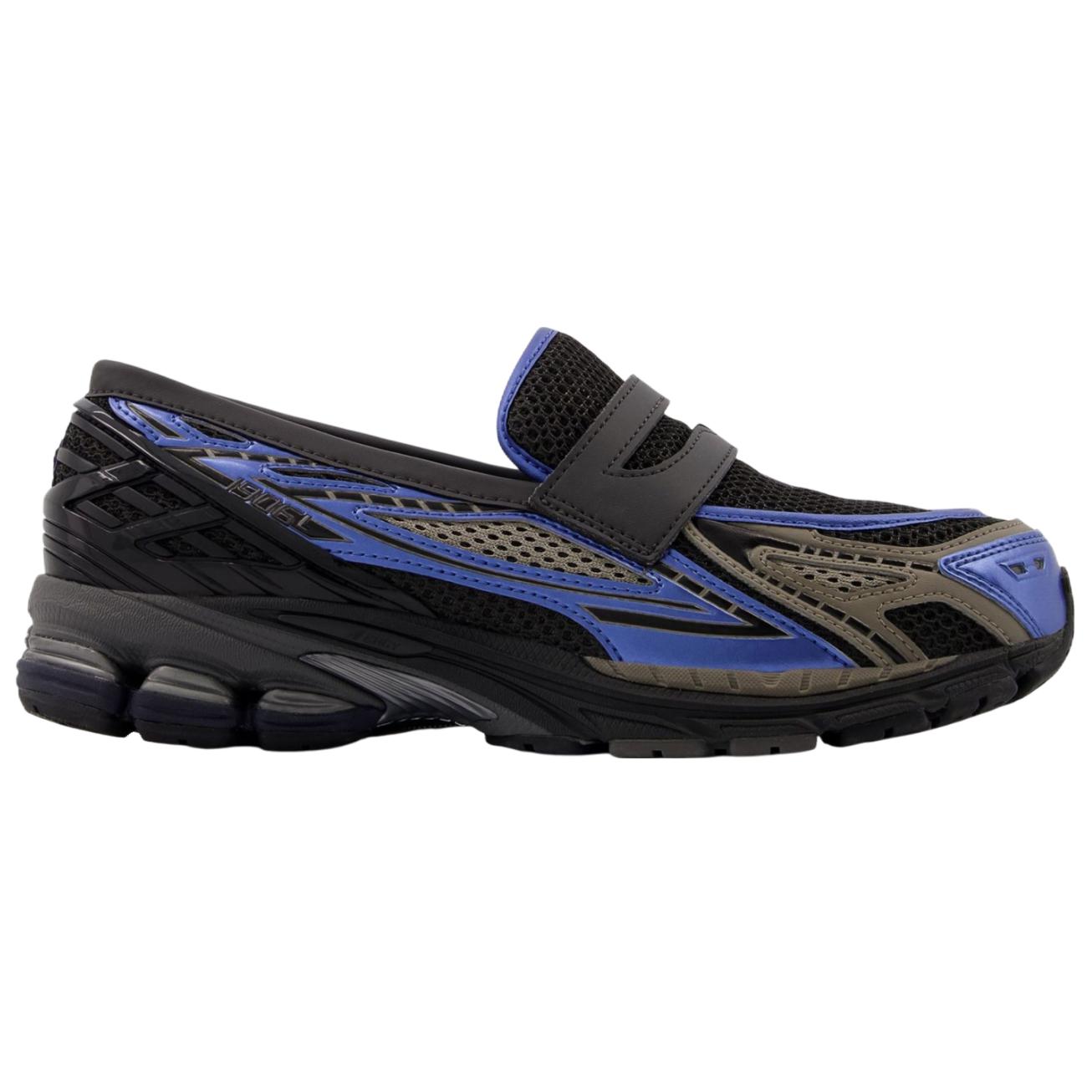 Detailed side perspective highlighting شوز نيو بالانس الأصلي featuring the unique black and blue color blocking and breathable mesh.