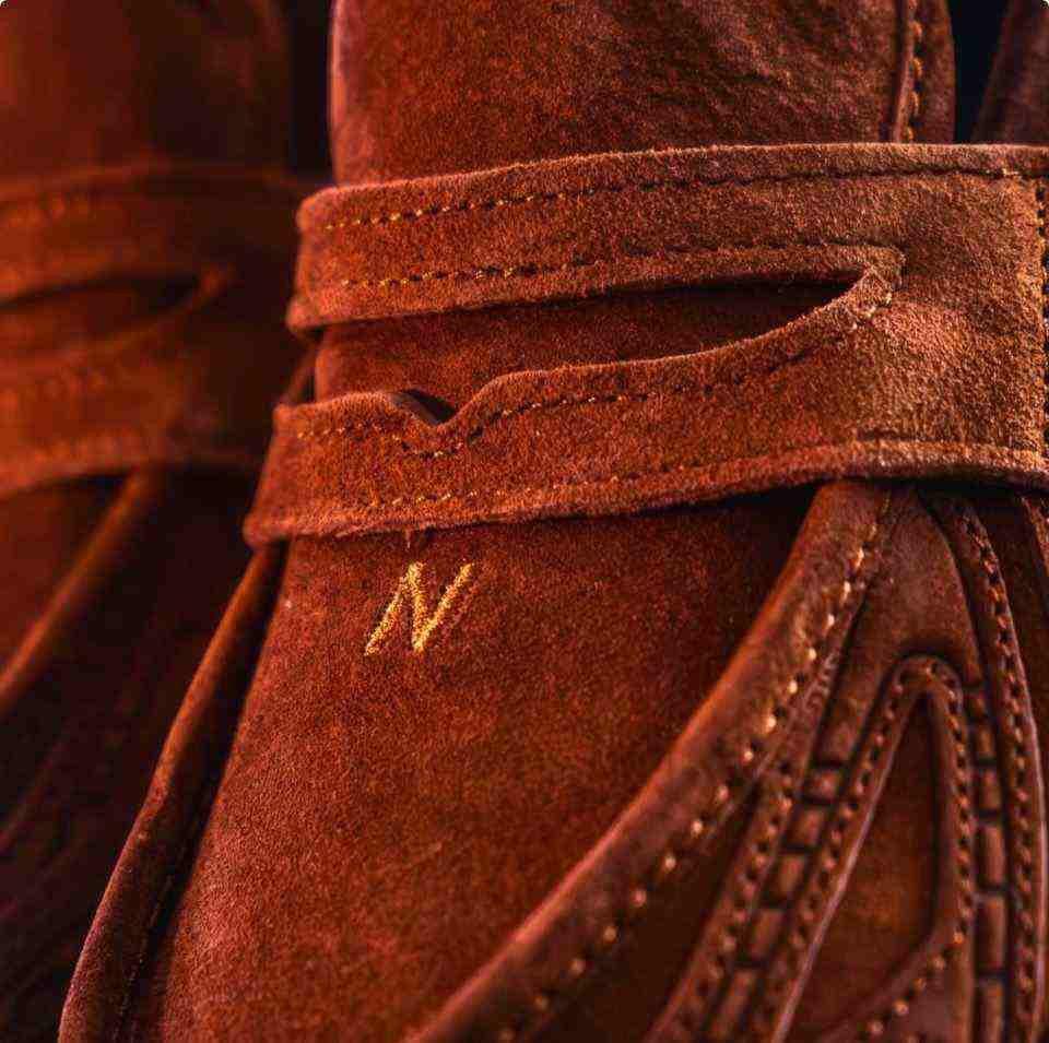 Macro texture view featuring حذاء نيو بالانس focusing on the strap embroidery and material quality.