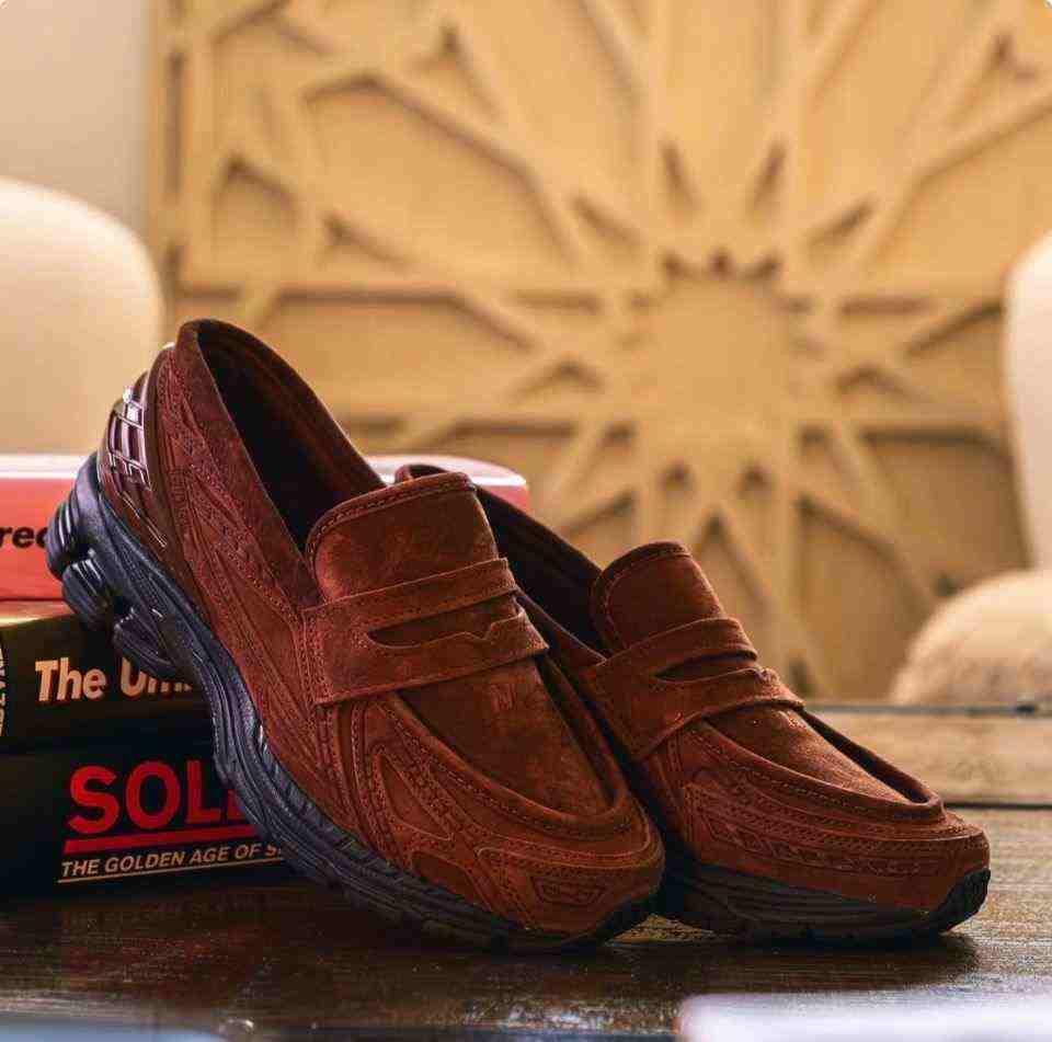 Aesthetic environment shot highlighting the New Balance 1906L Reddish Brown resting on a tabletop.