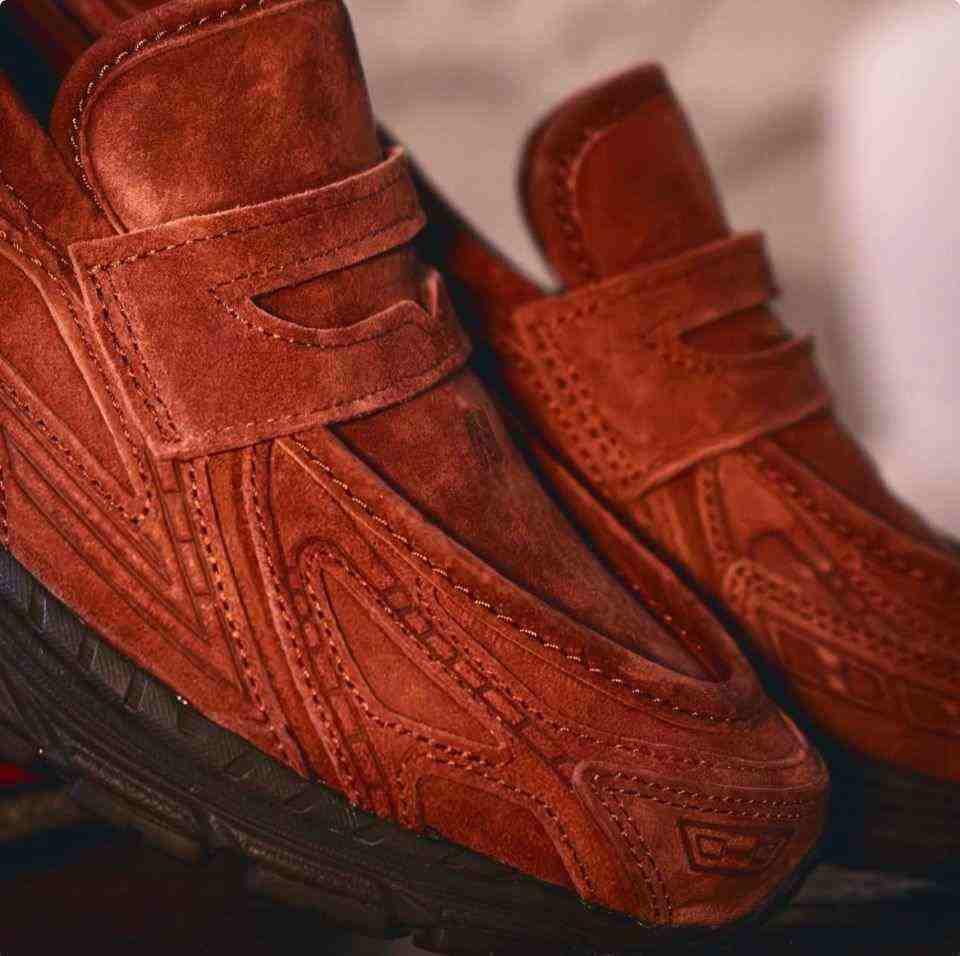 Close-up angle of شوز نيو بالانس الأصلي showcasing the rich reddish-brown suede and mesh pattern.