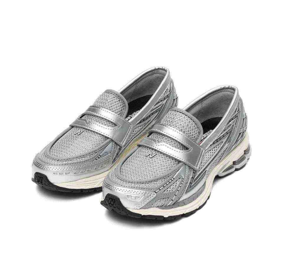 Perspective view of شوز نيو بالانس الأصلي (Original New Balance shoe) displaying the metallic strap and breathable mesh structure.