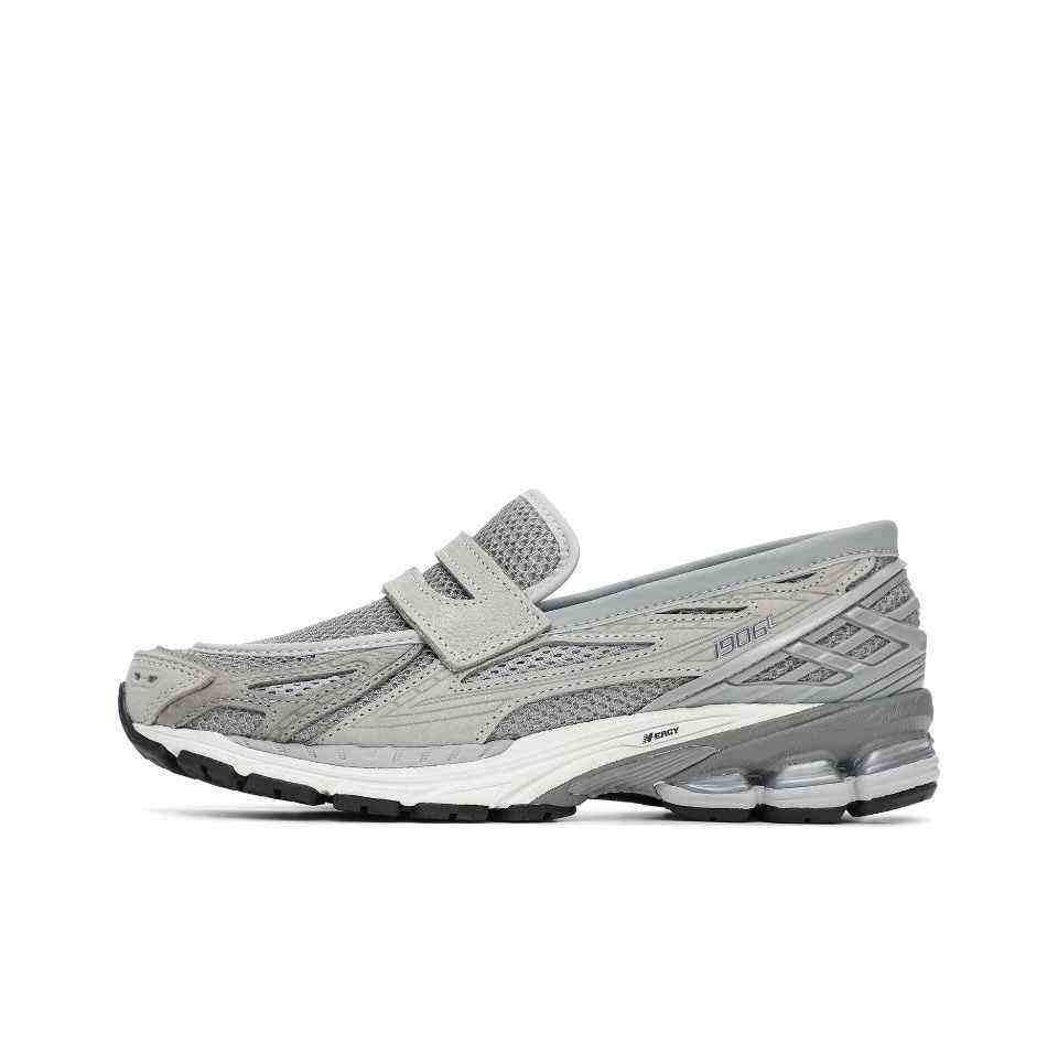 A close-up side perspective of the front portion of the New Balance 1906L grey, detailing the mesh material, synthetic overlays, and the distinctive Nロゴ. Popular choice for new balance 1906l men and women (نيو بالانس 1906L رمادي للنساء والرجال).