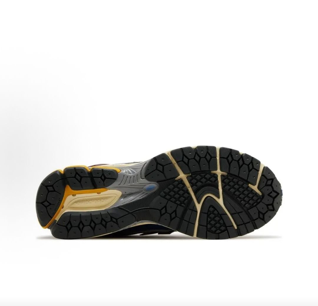 New Balance shoes 1906R model bottom sole view showcasing black rubber Ndurance traction tread, yellow heel inserts, and a midfoot Stability Web arch support shank.