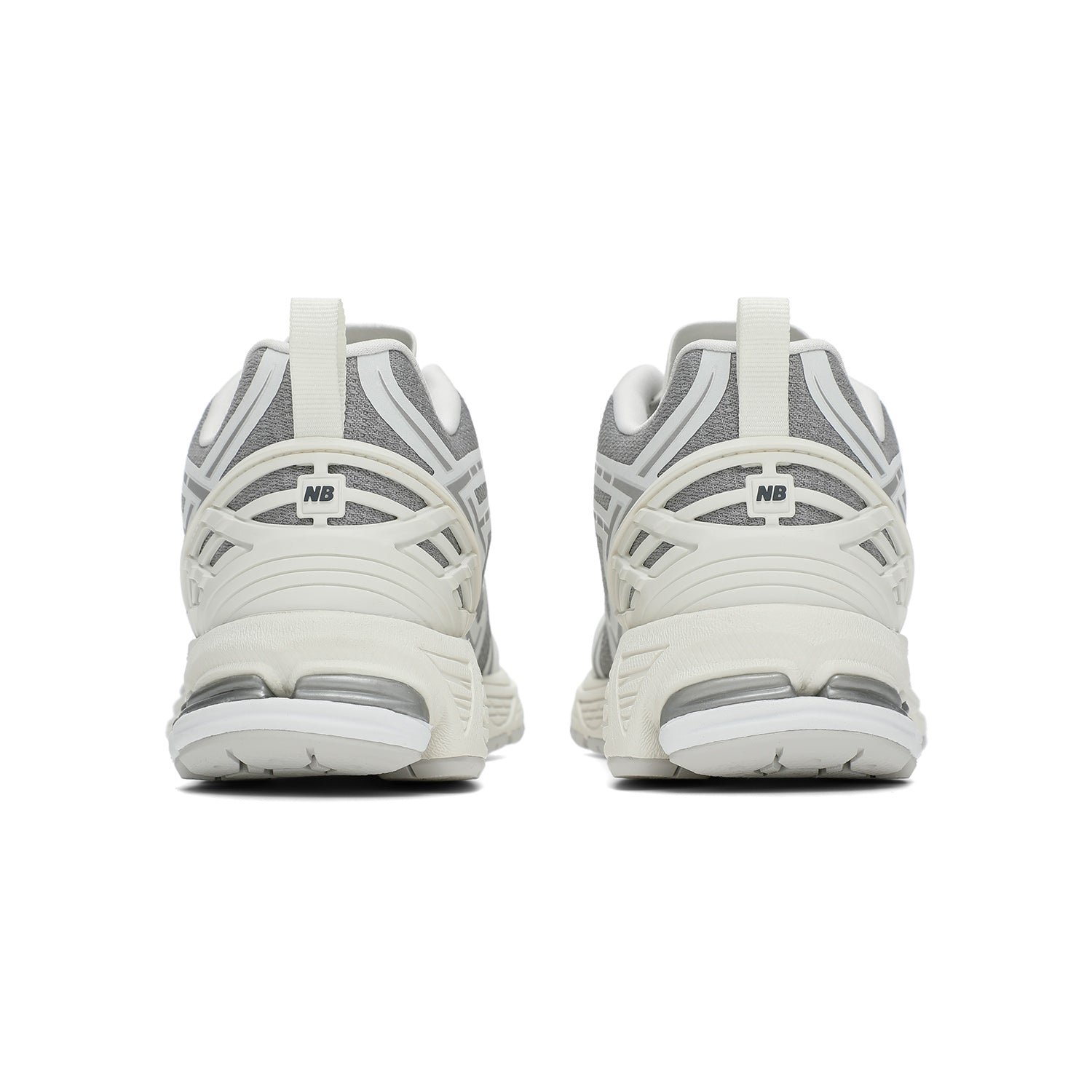 New Balance shoes 1906R model in grey and white colorway, rear heel perspective displaying off-white TPU support cages, fabric heel pull tabs, textured mesh collars, and N-ergy shock-absorbing midsoles.