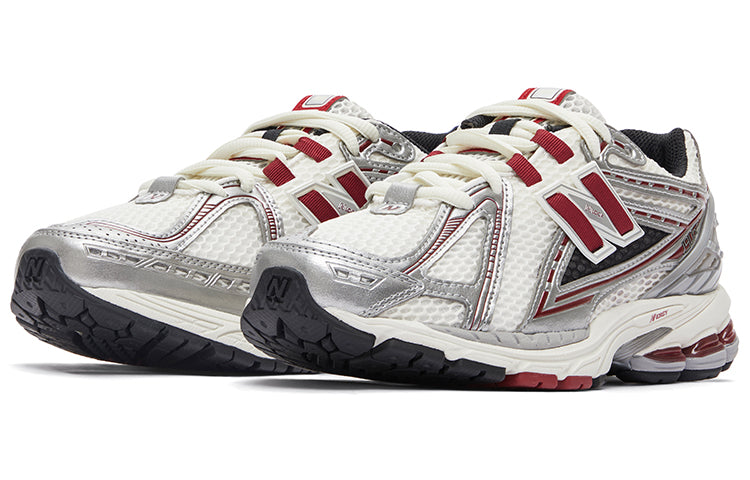 New Balance shoes 1906R model in white, metallic silver, and burgundy colorway, three-quarter perspective displaying breathable mesh uppers, structural metallic overlays, red N-lock support lace webbing, and shock-absorbing N-ergy midsoles.