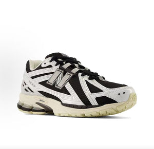 New Balance shoes 1906R model, three-quarter perspective displaying black mesh upper, white structural overlays, N-lock lacing system, and N-ergy shock-absorbing soles.