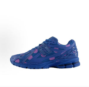 New Balance shoes 1906R running sneaker in blue polka dot pattern, lateral profile view showcasing blue and purple mesh uppers, structural cage overlays, N-lock support lace webbing, and N-ergy shock-absorbing soles.