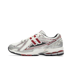 New Balance shoes 1906R running sneaker in white, metallic silver, and burgundy colorway, lateral profile view showcasing mesh uppers, structural metallic overlays, red N-lock support lace webbing, and N-ergy shock-absorbing midsoles.