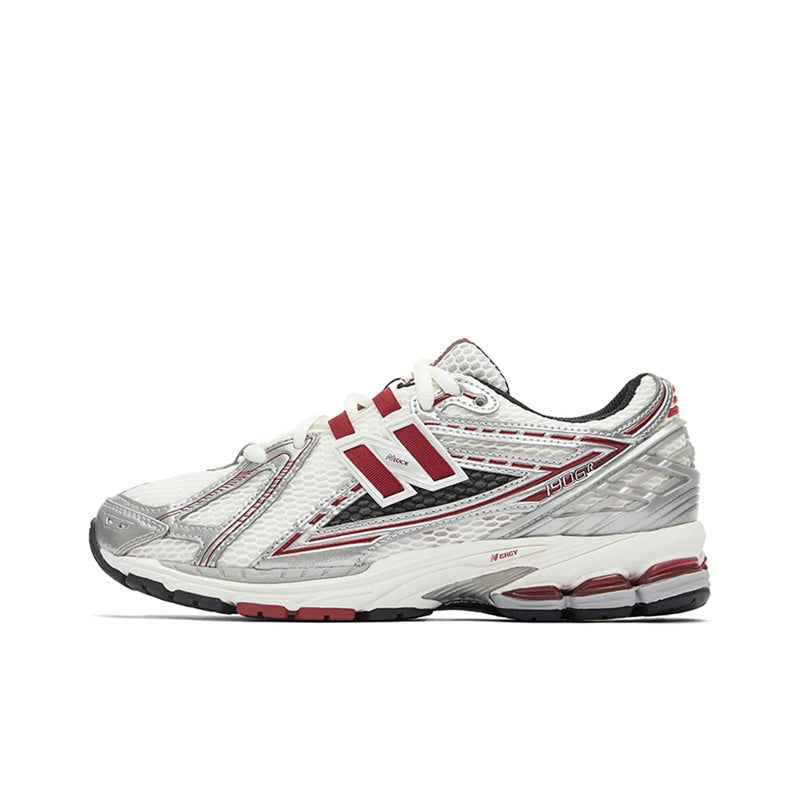 New Balance shoes 1906R running sneaker in white, metallic silver, and burgundy colorway, lateral profile view showcasing mesh uppers, structural metallic overlays, red N-lock support lace webbing, and N-ergy shock-absorbing midsoles.
