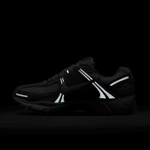 The glowing elements emphasize Nike Shoes and حذاء نايك الأصلي، مع أناقة شوز نايك وجمال حذاء رياضي Vomero 5 رمادي فاتح بتفاصيل عاكسة ضمن موديلات nike schuhe.