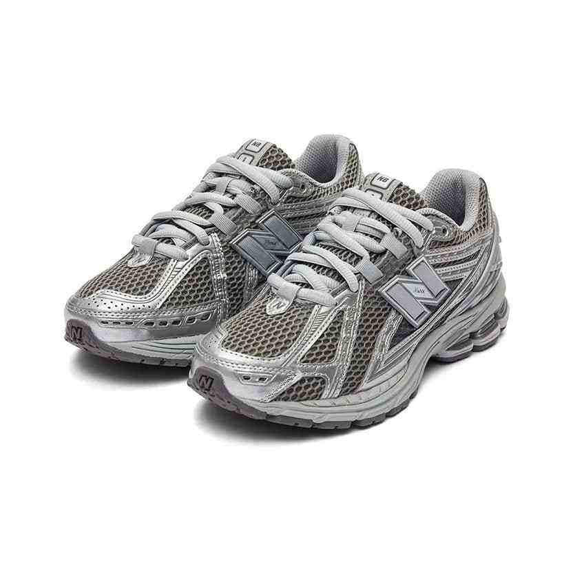 Pair of dark grey and metallic silver New Balance shoes shown at a three-quarter angle, featuring breathable wide-mesh uppers, silver metallic cage overlays, grey laces, and cushioned soles