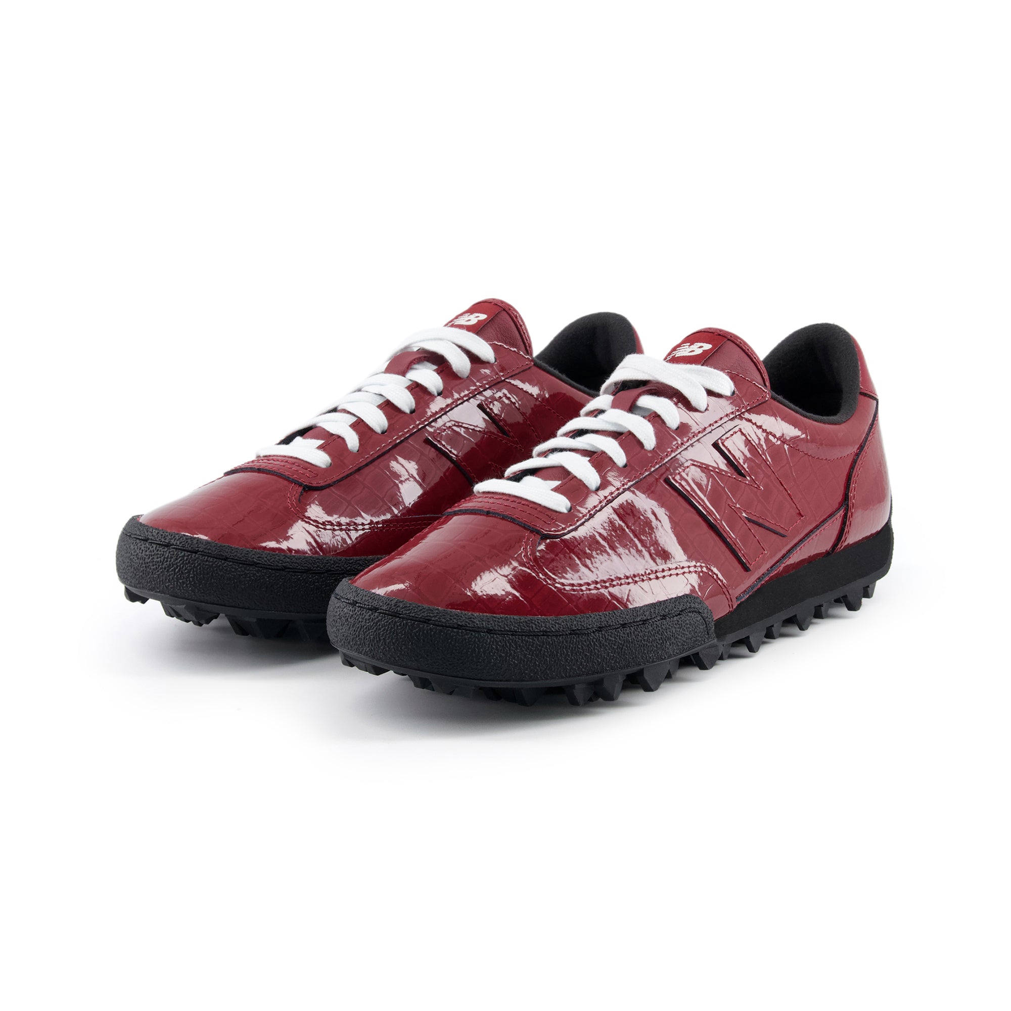 Three-quarter profile view of a pair of burgundy patent leather New Balance RC30 shoes with white laces.