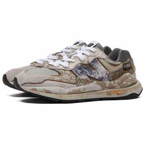 Three-quarter view of custom distressed multi-patterned New Balance running shoes.