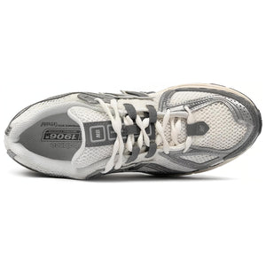 Top-down aerial view of metallic silver and cream New Balance shoes 1906R model, displaying open-cell cream mesh uppers, metallic silver synthetic overlays, dark grey N-Lock lacing webbing, white laces, padded collar lining, and grey branded OrthoLite insoles.