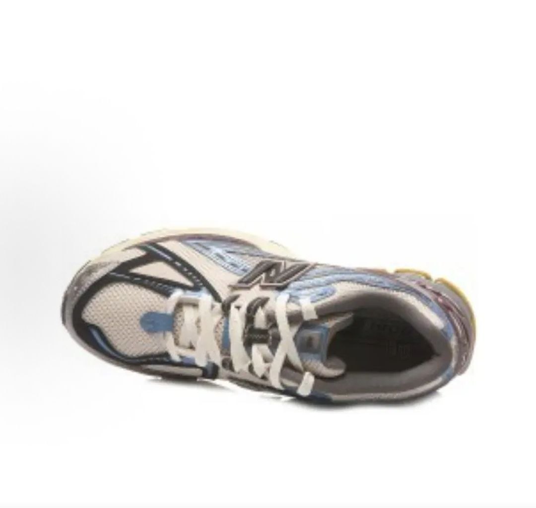 Top-down angled view of a single white, metallic blue, and purple New Balance shoes 1906R sneaker.