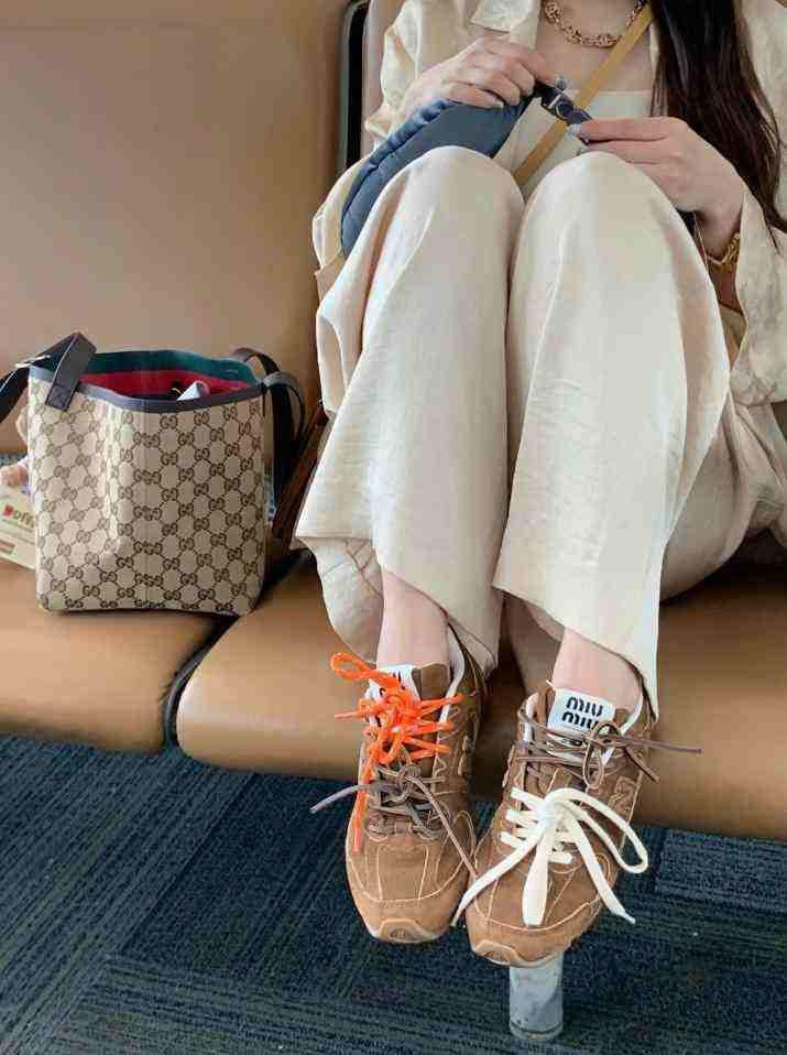 Top-down view of brown suede New Balance x Miu Miu shoes with multi-colored double laces.