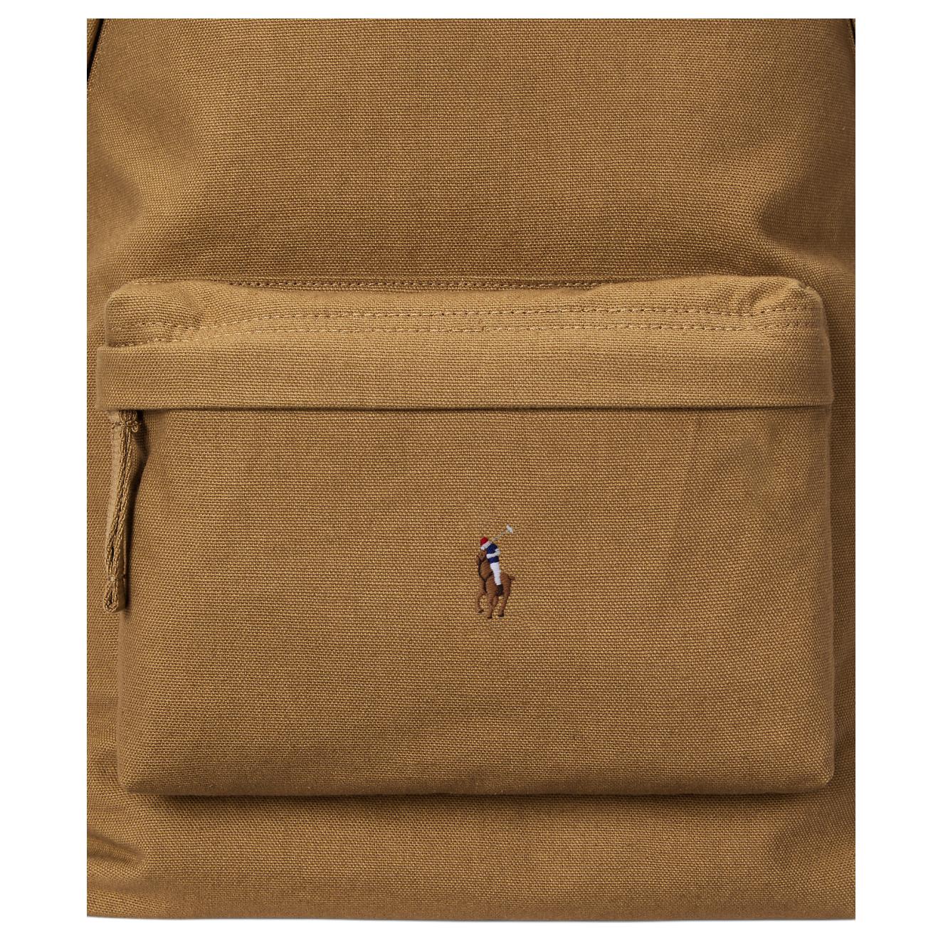 Detailed close-up of the front zipped pocket and signature embroidered pony logo on an authentic camel Polo Ralph Lauren backpack.

لقطة قريبة مكبرة للجيب الأمامي ذي السحاب وشعار المهر المطرز المميز على حقيبة ظهر Polo Ralph Lauren أصلية باللون الجملي