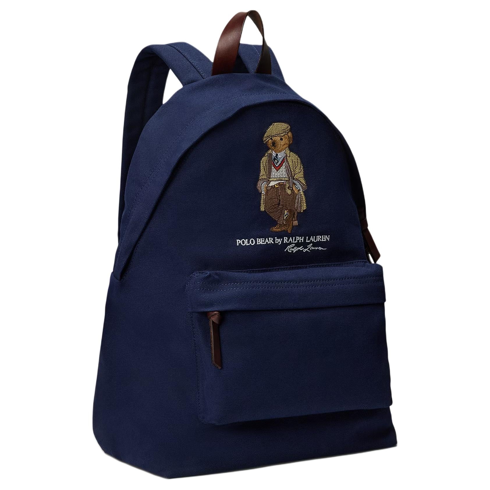 Side angle view of an original Ralph Lauren Polo Bear navy blue backpack showing brown leather zipper pulls and durable canvas fabric for school essentials.

عرض من الزاوية الجانبية لحقيبة ظهر Ralph Lauren Polo Bear كحلي أصلية يوضح أشرطة السحاب من الجلد البني والقماش المتين لمستلزمات المدرسة.