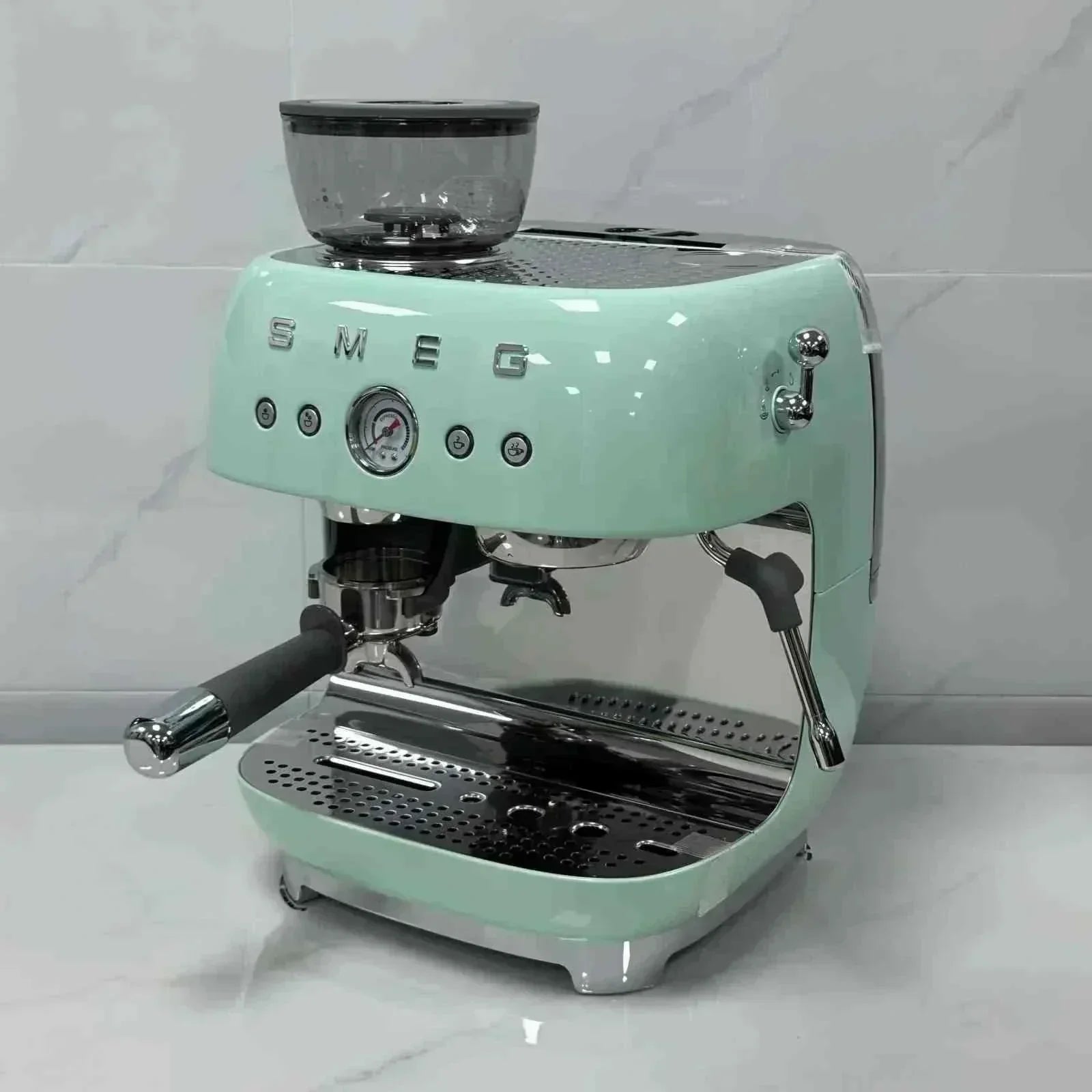 صانعة قهوة Smeg مع مطحنة باللون الأخضر الباستيل pastel green studio setup view.