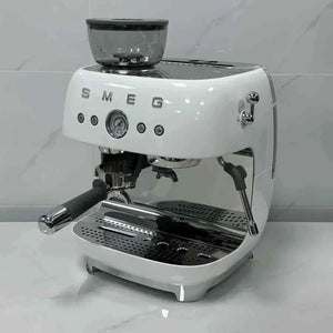 الة قهوة Smeg مع مطحنة مدمجة باللون الأبيض الناصع white studio view.