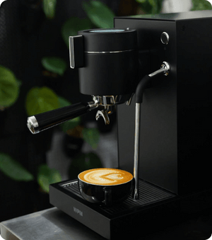 مكينة قهوه WPM KD-410 باللون الأسود coffee corner view توضح فنجان لاتيه آرت محضر بالماكينة.